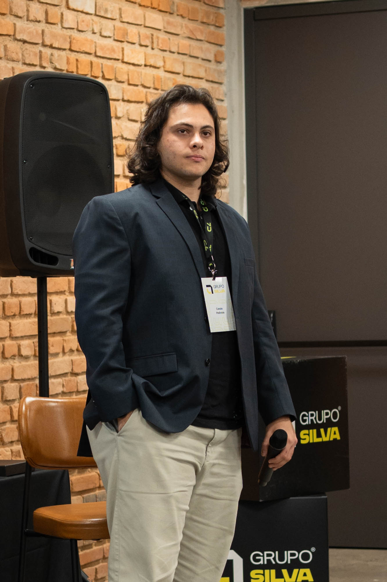 Cássio Branco de blazer, em pé durante um evento profissional